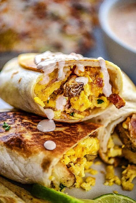 up close of a breakfast burrito drizzled with sauce Breakfast Burrito Dipping Sauce, Best Burittos Recipes, Grilled Breakfast Burritos, Sauce For Breakfast Burritos, Blackstone Breakfast Burritos, Breakfast Burrito Sauce Recipe, Breakfast Burrito Sauce, Burrito Sauce Recipe, Blackstone Breakfast