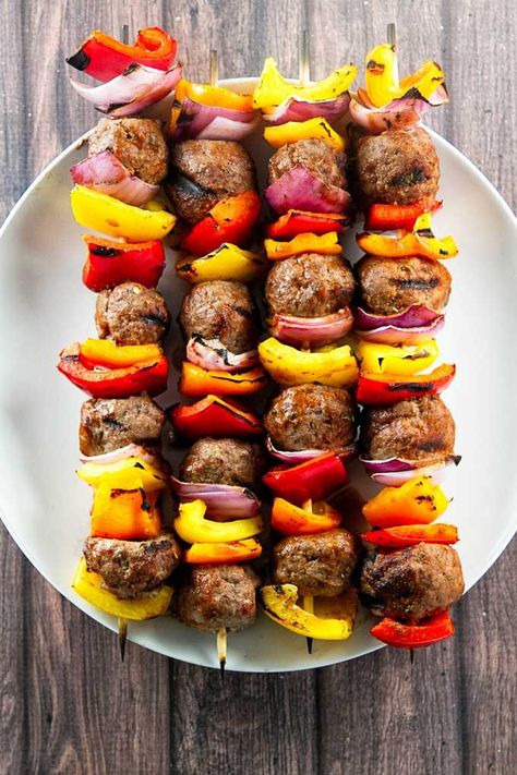 Grilled Italian Beef Skewers with fresh bell peppers, red onion, and homemade meatballs. The meatballs are brushed with a simple tomato glaze that takes about two minutes to mix-up! This is the best kind of summer comfort food. Pop over to my site for the recipe! | dinner ideas | ground beef recipes | summer recipes | Meatballs Beef, Meatball Skewers, Juicy Meatballs, Kabob Skewers, Beef Skewers, Italian Beef, Beef Meatballs, Homemade Meatballs, Kebabs