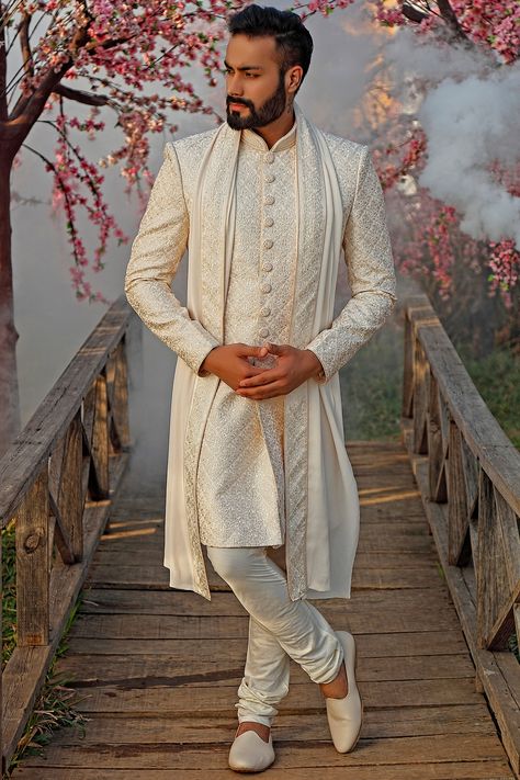 Featuring a pearl white sherwani in raw silk base with all over self embroidery. It is paired with matching churidaar pants and a dupatta.  FIT: True to size. COMPOSITION: Raw silk. CARE: Dry clean only. White Sherwani, Nikah Outfit, Sherwani For Men Wedding, Embroidered Sherwani, Wedding Dresses Men Indian, Sherwani Groom, Mens Sherwani, Sherwani For Men, Wedding Sherwani