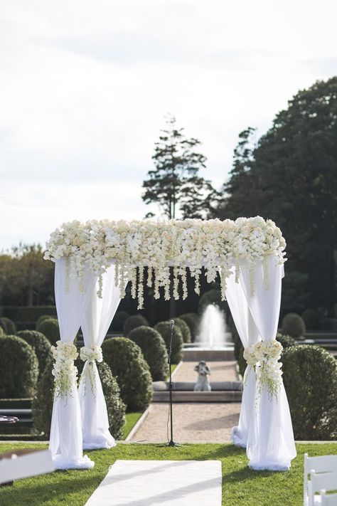 Wedding Arch With White Drape, White Square Wedding Arch, White Venue Wedding Decor, White Wisteria Wedding Arch, Gazebo Arch Wedding, Elegant Wedding Arches, All White Floral Arch, Chuppah White Flowers, Simple Elegant Wedding Arch