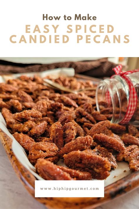 small jar with a ribbon laying flat on a tray with candied pecans