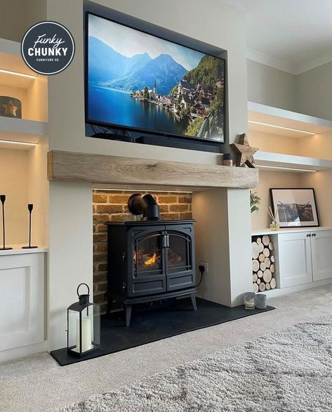 This image shows a neutral-toned living room that has white walls and alcove shelving. On the main wall, there is one of our oak mantels which has added the perfect finishing touch to the room. Tv Above Log Burner, Log Burner Tv Wall, Chunky Furniture, Cedar Beams, Alcove Ideas Living Room, Alcove Ideas, Wood Burning Stoves Living Room, Log Burner Living Room, Neutral Colour Scheme