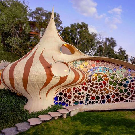 NAUCALPAN, MEXICO Nautilus House 19.4773 -99.2793 Fantastical house shaped like a seashell brings aquatic design to architecture.  A young family tired of their conventional home yearned to live in something a little more intergrated with nature. Their wish was granted by Javier Senosiain of Senosiain Arquitectos, a celebrated Mexican architect whose work is considered both pioneering and controversial in the field of bioarchitecture. Nautilus House, Aquatic Design, Organic Interior Design, Organic Interior, Beach Architecture, Houses In Mexico, Organic House, Bottle House, Shell House