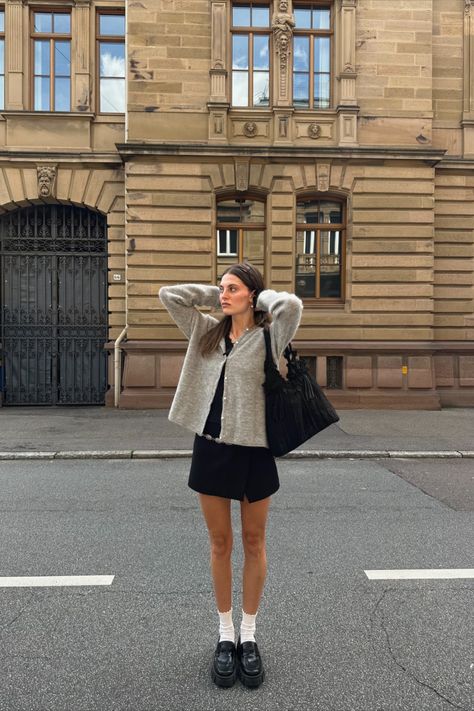 @luisa.zkr is wearing Sézane iconic Gaspard grey knit cardigan. The short black dress, white socks and black leather loafers are personal pieces. Short Grey Cardigan Outfit, Socks And Loafers Outfit, Loafers And Socks Outfits, Casual Parisian Outfits, Loafers Outfit Fall, Platform Loafers Outfit, Dress With Loafers, Gaspard Cardigan, Outfits With Grey Cardigan