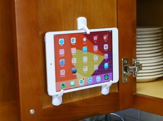 Protect your tablet from splashes and read recipes at eye level. All for just a few dollars. Plastic Bag Storage, Diy Blinds, Ipad Holder, Custom Blinds, Plastic Baskets, Command Hooks, Cling Wrap, Hook And Loop Tape, Household Hacks