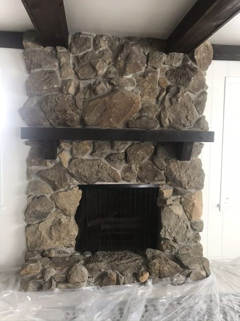 Stone Fireplace Wood Paneling, Over Grouted Stone Fireplace Before And After, Diy Wood Fireplace Cover, Painting Faux Rock Fireplace, Dark Stone Fireplace Makeover, Fieldstone Fireplace Makeover, Black Wash Stone Fireplace, Black Stone Fireplace Ideas, German Smear Stone Fireplace