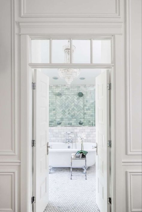 Elegant entry to a classic white bathroom. French doors with interior transom and paneled molding open to a marble bath with clawfoot tub and empire style crystal chandelier. Design by The Fox Group. #elegantdecor #bathroomdesign #traditionalstyle #classicbathroom #frenchdoors Bathroom Classic Design, The Fox Group, Classic White Bathrooms, Fox Group, Bathroom Freestanding, Timeless Interior Design, French Country Bathroom, Timeless Interior, Classic Interior Design