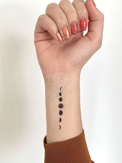 Discover the allure of Moon phase tattoos. We will explore the best designs and insights on choosing the ideal placement. Moon Cycle Tattoo, Moon Phases Tattoo, Small Wrist Tattoos, Wrist Tattoos For Women, Phases Of The Moon, Classy Tattoos, Discreet Tattoos, Elegant Tattoos, Design Tattoo