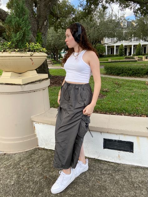 Girl standing wearing a white tank top, maxi skirt, and headphones Parachute Skirt Outfit Summer, Grey Cargo Skirt Outfit, Maxi Cargo Skirt Outfit, Parachute Skirt Outfit, Long Cargo Skirt Outfit, Pattern Moodboard, Cargo Skirt Outfit, Maxi Skirt Outfit, Skirt Outfit Summer