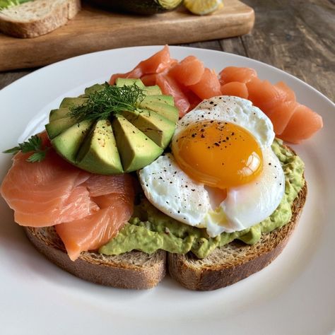 🥑 Avocado & Smoked Salmon Toast A Delicious and Nutritious Breakfast with Poached Egg Ingredients: For the Toast: 2 slices of whole-grain bread, toasted 1 ripe avocado, mashed 4 slices smoked salmon 2 large eggs 1 tablespoon white vinegar Salt and pepper to taste Fresh dill or chives for garnish (optional) Lemon wedges for serving Directions: Prepare the Avocado Spread: Mash the ripe avocado in a bowl until smooth. Season with salt and pepper to taste. Set aside. Poach the Eggs: Bring a ... Smoked Salmon Toast, Avocado Smoked Salmon, Salmon Toast, Avocado Spread, Salmon Eggs, Grain Bread, Salmon Avocado, Egg Toast, Poached Egg