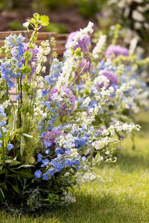 Blue delphinium, white larkspur, giant purple allium, bells of ireland, kiwi vine, lysimachia, queen anne's lace ceremony aisle floral hedge White Green Purple Blue Wedding, Delphinium Wedding Aisle, Allium Wedding Flowers, Blue Purple Green Wedding Color Palettes, Blue Delphinium Wedding, Wedding Ceremony Aisle Flowers, White Wildflower Wedding, Wildflower Wedding Ceremony, Blue Wedding Florals