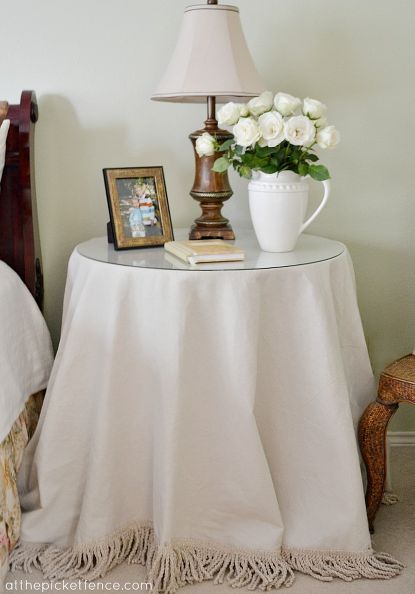 a way too easy no sew drop cloth table skirt with fringe, crafts, Once freshly laundered a painter s drop cloth becomes wonderfully soft and almost linen like Covered Furniture, Drop Cloth Projects, Bullion Fringe, Table Skirts, Canvas Drop Cloths, Bedroom Table, Round Tables, Table Skirt, Drop Cloth