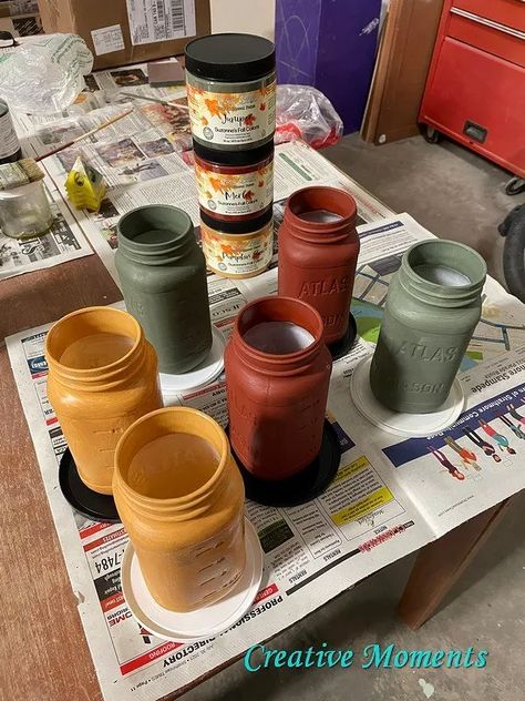 Where are my fall color fans?? These mason jars turned rustic vases are done in fall shades of green, red and yellow.  Dixie Belle Paint has released 5 limited new fall colors; juniper, merlot and pumpkin spice shown above as well as latte and cashmere This great sized mason jars come filled with spaghetti sauce and make a perfect vase. I run thru the dishwasher once emptied. Many chalk paints claim you can just paint over any surface but to have better adherence I brush… Diy Fall Decor Mason Jars, Painting Jars With Chalk Paint, Fall Mason Jar Arrangements, Pumpkin Mason Jars, Autumn Mason Jars, Fall Painted Mason Jars, Fall Painted Bottles, Fall Mason Jar Crafts Diy, Fall Crafts With Mason Jars