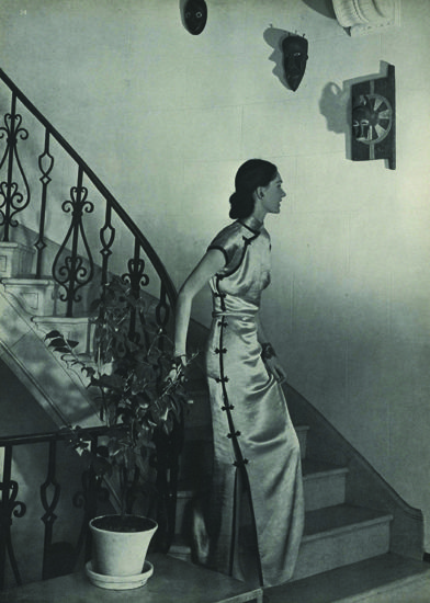 Figure 9. “Celestially Narrow: Dinner-­at-­home dress Mme. Chiang—­or you—­might wear. (Here coming down the stairway in Princess Gourielli’s house.) Topaz-­coloured rayon satin—­far narrower than W.P.B. prescribes. $35. Chez Rosette; I. Magnin; Carson Pirie Scott.” Horst P. Horst, photographer. Vogue, May 1, 1943, p. 34 Vintage Asian Fashion, Shanghai Aesthetic, Qipao Vintage, Horst P Horst, Mary Martin, Old Shanghai, Shanghai Fashion, And July, China Dress