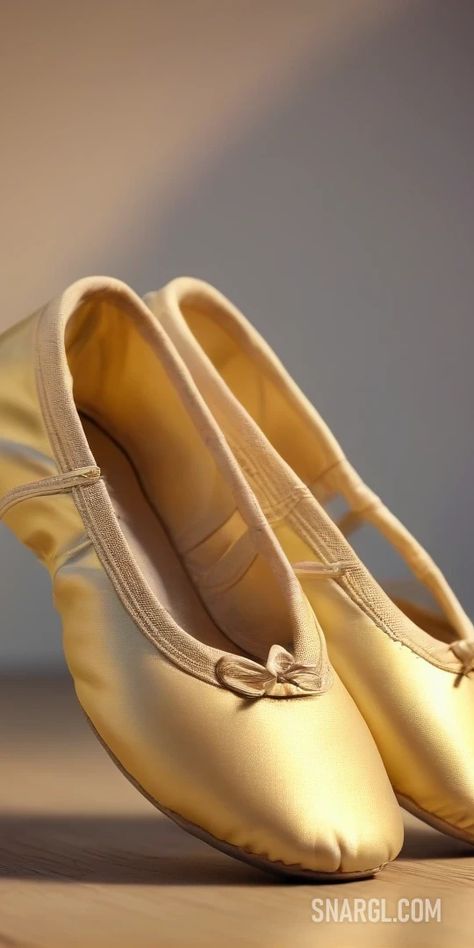 Pair of gold ballet shoes on a wooden floor with a shadow of a wall behind them. Example of PANTONE 437 color. PANTONE, PANTONE 437. Cute fashion and beauty.Follow us and visit our site for more amazing content! #graphic #outfit #ballet #hairstyle #color. #lotion #beauty #AI #aesthetic #shoes #PANTONE437 #heels #Pair #necklace #mask