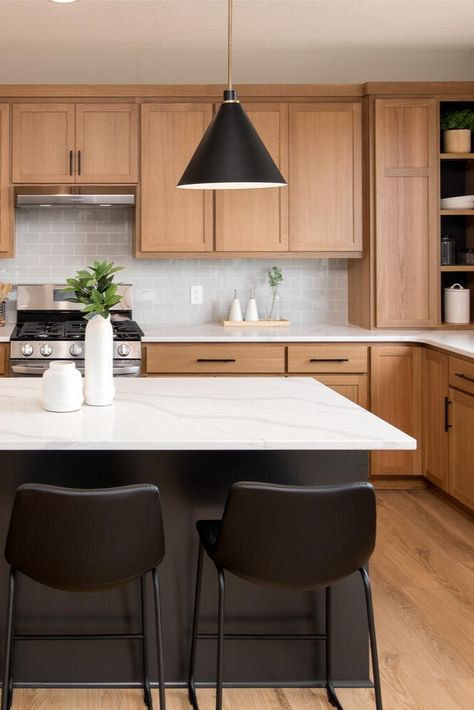 It’s our favorite time of the year! The Spring #ParadeofHomesTC is on now through April 7. 🌷☀️ 🌈  __ Oak cabinets, black kitchen island with black barstools, floating pendants, white countertops, kitchen goals, light wood floors. White Cabinets Wood Island Black Counter, Oak Wood And Black Kitchen, Oak Cabinets Black Island, Black Kitchen Island Wood Cabinets, Light Wood And Black Kitchen, Black Island Wood Cabinets, High Contrast Kitchen, Contrast Kitchen, Light Wood Kitchens