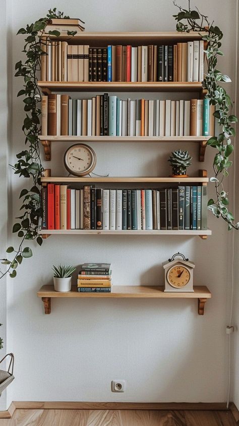 Stylish vertical bookshelf with books, potted plants, and clocks creating a serene home ambiance. Shelf Ideas Aesthetic, Book Shelf Ideas Aesthetic, Bookshelf Styling Ideas, Book Shelves Wall, Bookshelf Decor Ideas, Stylish Bookshelf, Book Shelf Ideas, Lucy Loo, Studio Makeover