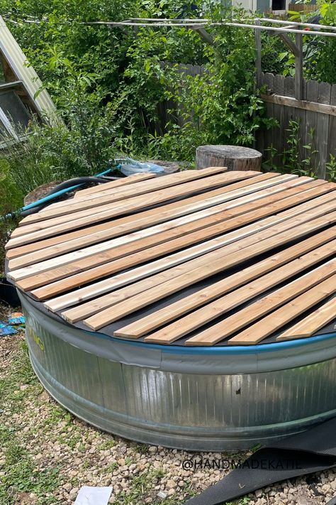 A wood-slatted cover is sitting on top of a metal stock tank pool. Stock Tank Pool Hot Tubs, Stock Tank Pool Cover, Stock Tank Pool Deck, Plastic Stock Tanks, Stock Pool, Stock Tank Pool Ideas, Galvanized Stock Tank, Stock Tank Swimming Pool, Cowboy Pool