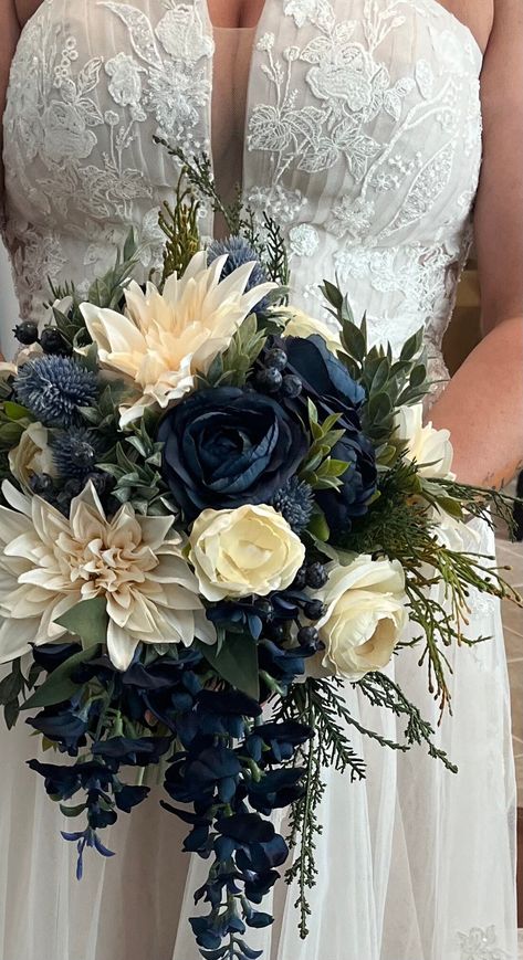 CONGRATULATIONS on your upcoming wedding! This beautiful silk flower bridal bouquet is a romantic inspired blue and ivory bouquet made with a stunning mix of faux/artificial flowers. Gorgeous greenery completes the look and all stems are flawlessly wrapped in ribbon of your color choice. Bouquet measures approx. 14"in diameter by 18" in length (although other diameters are available in drop down menu). Shown here tied with ribbon, but if you are interested in luxurious silk ribbon, this is available for an extra charge. If interested, please message us with the ribbon color you would like.  Matching wedding flowers are also available, so please ask us about a full wedding flower package including bridesmaid bouquets, boutonnieres, corsages and hair wreaths. Your order will be packaged secu Navy Blue Flowers Wedding, White And Navy Blue Bouquet, Navy Wedding Accents, Navy Blue And Ivory Wedding Decorations, Navy Gold Wedding Flowers, Blue Wedding Ideas Decoration, Navy Flowers Wedding, Navy And Sage Wedding Cake, Navy Blue Flowers Bouquet