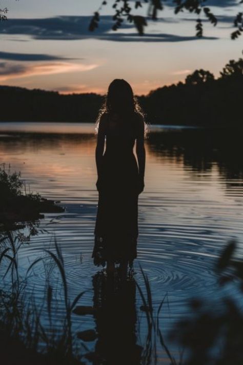 Silhouetted person standing in calm water with reflections at sunset. Nature Photography Professional, Lake Aesthetic Photoshoot, Summer Evening Photoshoot, Moody Lake Photoshoot, Aestethic Photoshoot Ideas, Moody Water Photoshoot, Creek Photoshoot Ideas, Cute Summer Photoshoot Ideas, Cool Photoshoot Ideas Creative Unique