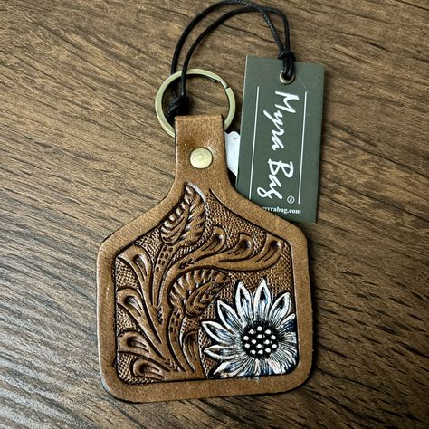 Myra Leather Keychain Product Details With A Classic Scroll Pattern, This Hand-Tooled Leather Fob Depicts A Wondrously Colorful Sunflower Perhaps A Moonflower Sunflower? Includes Standard Key Ring. More Information Materials Leather Item Width 2 Length 4 Leather Tooled Keychain, Leather Crafts To Sell, Tooled Leather Flower, Tooled Flowers, Leather Mason Jar, Leather Accessories Diy, Flowers Keychain, Blacksmith Ideas, Colorful Sunflower