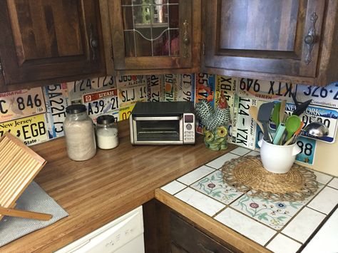 License Plate Backsplash done today! #licenseplate License Plate Backsplash, Taxidermy Room, License Plate Wall, Plate Ideas, Vintage License Plates, Rustic Kitchen Cabinets, Car Tag, Antique Decor, Wall Covering