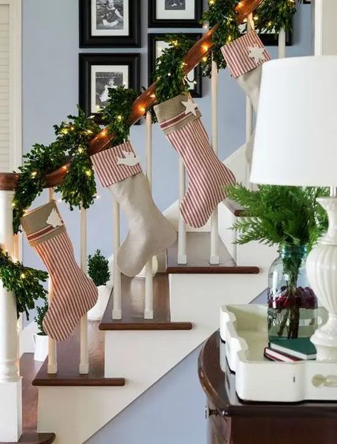 evergreen garland that wraps the banister and striped stockings Hanging Stockings On Staircase, Stockings On Staircase, Christmas Garland Staircase, Staircase Christmas, Evergreen Garland, Christmas Banister, Indoor Railing, Staircase Decor Ideas, Christmas Staircase Decor