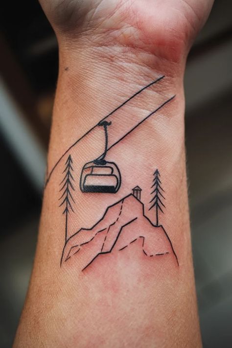 Cable car tattoo with mountains and pine trees on a person’s forearm. Skier Tattoo Ideas, Snowmobile Tattoo, Ski Tattoo Ideas, Skiing Tattoos, Wrist Tattoo Design, Small Wrist Tattoo Ideas, Snowboarding Tattoo, Skiing Tattoo, Minimalist Symbols