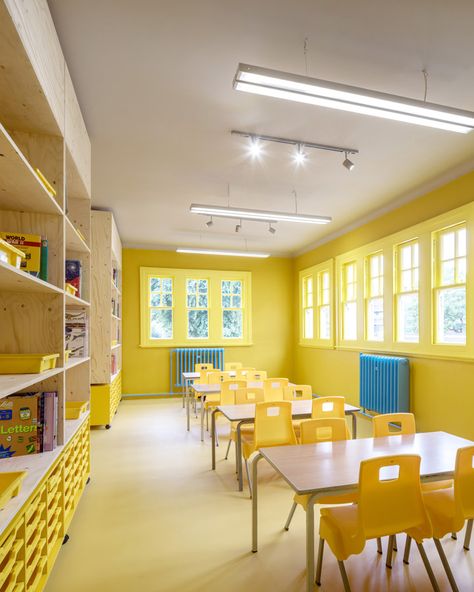 One classroom has bright yellow walls, floors and furniture, with wooden storage walls and sky-blue radiators. Classroom Paint Colors Wall Schools, Storage Walls, Clashing Colours, Colour Room, Classroom Interior, Schools Around The World, School Interior, Yellow Theme, Yellow Interior