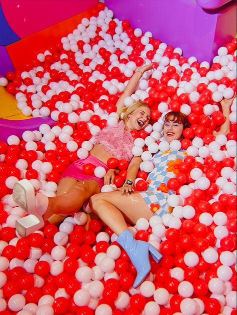 Kimmygrace and peachyskater in a big red and white ball pit wearing fun colourful outfits. #dopaminedressing #ballpit #colourfuloutfits #retrofashion Ball Pit Photoshoot, Ball Pit For Adults, Ball Pit Fun, White Ball Pit, Mission Accomplished, Red Ball, Ball Pit, Jump In, Bid Day