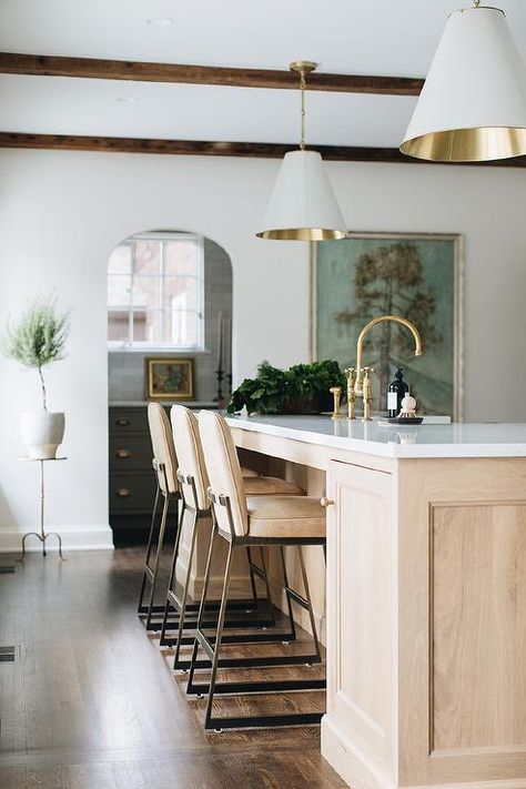 Light brown leather counter stools sit at a light brown brushed oak center island fitted with an antique brass deck mount faucet and an apron sink illuminated by two white and gold Goodman Hanging Lamps. Banquette Living Room, Jean Stoffer Design, Jean Stoffer, Kitchen Post, Brass Interior, Home Luxury, Painted Brick, Large Kitchen, White Cabinets