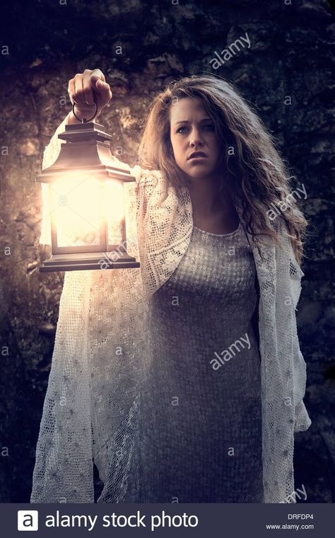 Woman holding lantern in the dark Stock Photo: 66108284 - Alamy Carrying Lantern Reference, Woman Holding Something Pose, Holding A Lamp Reference, Holding Lantern Pose Reference Drawing, Woman Casting Spell Pose, Holding Lantern Pose Reference, Hand Holding Lantern Reference, Someone Holding A Lantern, Holding Hand Out Pose Reference