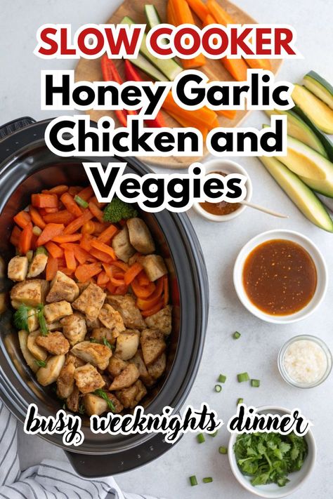 A delicious plate of Crockpot Honey Garlic Chicken and Veggies served alongside broccoli, carrots, and tomatoes. The dish showcases tender, golden-brown chicken pieces drizzled with honey garlic sauce, paired with vibrant, fresh vegetables. In the background, a slow cooker and fresh herbs on a wooden board complete the cozy kitchen scene. Perfect for a simple and flavorful dinner! Chicken And Broccoli Slow Cooker Recipes, Clean Crockpot Recipes Healthy, Easy Crockpot Meals Whole 30, Cleanfoodcrush Crockpot Recipes, Easy Clean Crockpot Meals, Easy Whole 30 Dinner Slow Cooker, Easy Healthy Dinner Slow Cooker, Gf Crock Pot Meals, Chicken Veggies Crock Pot