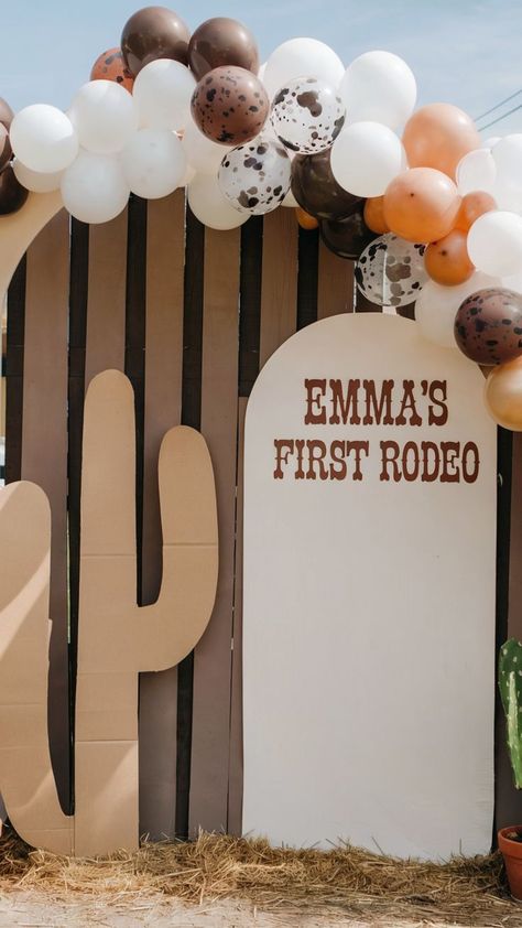 Western-themed first birthday setup with "Emma's First Rodeo" sign, cactus cutout, and a rustic balloon garland in earthy tones, creating a fun and playful outdoor atmosphere. Unique First Birthday Themes, First Birthday Party Ideas, Rodeo Baby, Rodeo Birthday Parties, Rodeo Party, Rodeo Birthday, Western Theme Party, 1st Birthday Themes, First Rodeo