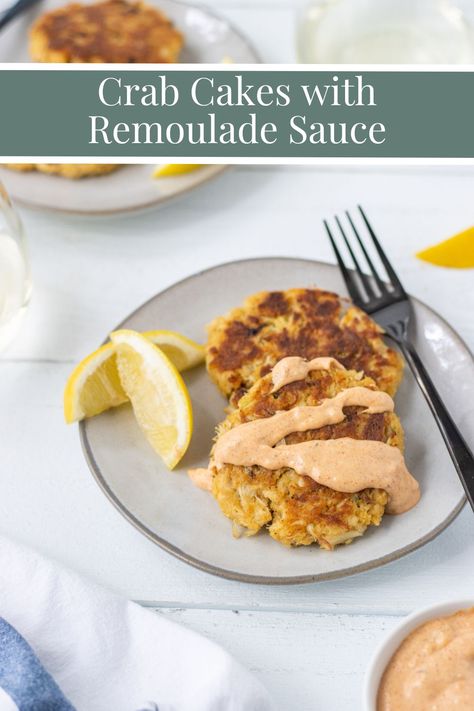 Crab cakes drizzled with remoulade sauce on a plate with lemon wedges. Remoulade Sauce Recipe Crab Cakes, Roumalade Sauce Crab Cake, Romulade Sauce Crab Cake, Crab Cake Remoulade Sauce, Southern Crab Cakes, Crab Cake Remoulade, Crab Cake Sauce, Lump Crab Cakes, Pink Sauce