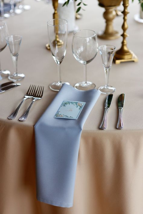 Dusty blue table napkins with cream table cloths and a flower print guest name cards Blue Napkin Wedding, Dusty Blue Table Cloth Wedding, Dusty Blue Napkins, Baby Blue Linen Party Table Images, White Tablecloth Blue Napkins Wedding, Blue Table Napkins, White Table Cloths Blue Napkins, Blue Linen Napkins Wedding, Napkins Wedding Table