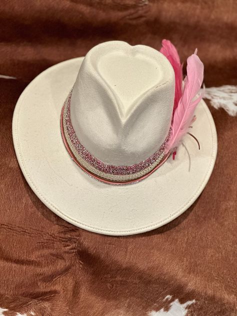 BRAND NEW STYLE!! HEART SHAPED CROWN- BE THE FIRST TO HAVE ONE OF THESE SUPER CUTE STYLE HATS!Beige hat, with a pink rhinestone bling band and leather wrapped band, various pink feathers and heart hat pin.  ONLY ONE AVAILABLE! Adorable hat! One size fits most! Hand wash only, lint brush for dusting Branded Cowgirl Hat, Western Car, Lint Brush, Beige Hat, Chapeau Cowboy, Painted Hats, Cowgirl Hat, Ball Caps, Handmade Brand