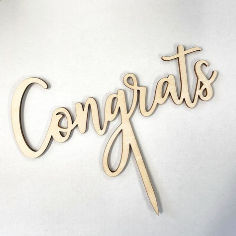 The perfect wood cake topper for a congratulations party cake! Description Natural celebration wood cake topper. Perfect for a congratulations cake! These cake toppers are laser cut from 2 mm thick plywood and are approximately 13-22 cm wide and 18 cm tall with a 8 cm stake for easy insertion into your cake. Avoid those nasty acrylic plastic toppers by using a more environmentally friendly material like wood. Rustic and beautiful giving your cake that wow factor! DISCLAIMER: The photo may be sli Congratulations Cake, Laser Cut Decor, Wood Cake Topper, Wood Cake, Wood Rustic, Colorful Cakes, Acrylic Plastic, Custom Cake Toppers, Party Cake