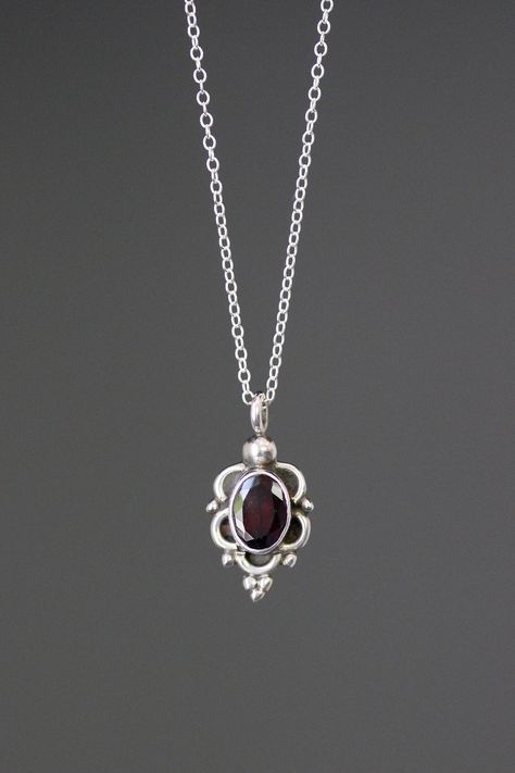 "A sweet Red Garnet oval stone is bezel set in a Bali Silver pendant. A silver chain is included. Choose from a 1mm silver chain with a silver spring ring clasp, or a 1.5mm silver chain with a silver lobster clasp. Each chain measures 16\" with an extension to 18\".  Please send a message if a different length chain is desired. A lovely gift for a young girl or someone who likes small, delicate jewelry.  Red Garnet stone: 5.5x8mm Bali Silver pendant: 10x19mm (including the ring at the top) Total Garnet Silver Necklace, Red Silver Necklace, Silver Red Jewelry, Garnet Pendant Necklace, Necklace With Small Pendant, Red Gemstone Necklace, Stone Jewelry Necklace, January Birthstone Jewelry, Vintage Silver Jewelry