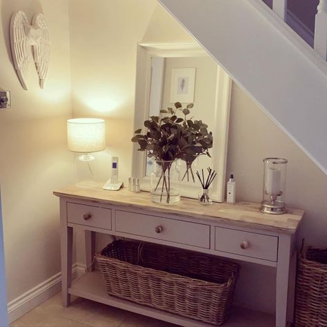 Placing a white mirror on the console table for under-stairs space ideas can create the illusion of a larger and brighter area. Additionally, incorporating a glass vase with fresh greenery can add a touch of nature and freshness to the space. White mirror from @homewithlaurajayne Hallway Decorating Colours, The Space Under The Stairs, Space Under The Stairs, Hallway Table Decor, Country Style Living Room, Tiny House Camper, Narrow Hallway Decorating, Hallway Designs, Cosy Living Room