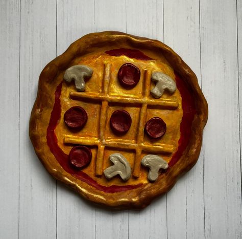 Enjoy this handmade pizza tic tac board with your family or friends. It would look great on any coffee table or game room! * Each piece can vary in painting style they are all hand painted. Ceramics Board Game, Handmade Tic Tac Toe Game, Pizza Tic Tac Toe, Air Dry Clay Projects Tic Tac Toe, Air Dry Clay Ideas Tic Tac Toe, Air Dry Tic Tac Toe, Homemade Ceramic Plates, Pizza Clay Art, Tictactoe Airdry Clay