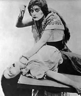 theda bara Theda Bara Makeup, Dramatic Sitting Pose, Leaning Towards Camera Pose, Growing Up Creepie Fanart, Tending To Wounds Reference, Old Person Reference, Eerie Poses, Woman Shushing, Redraw Images