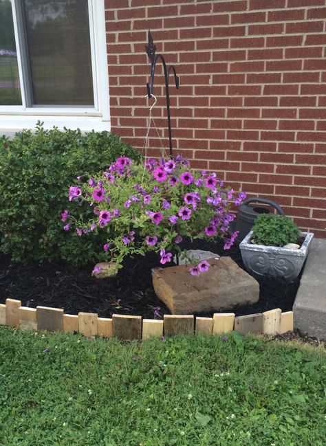 Pallet wood used as edging around flower beds Pallet Wood Flower Bed Border, Flower Bed Boarder Landscape Edging, Wooden Lawn Edging, Flower Bed Wood Border Ideas, Triangle Flower Bed Ideas, Wood Landscape Edging Ideas, Pallet Edging, Pallet Garden Edging, Flowerbed Edging Ideas