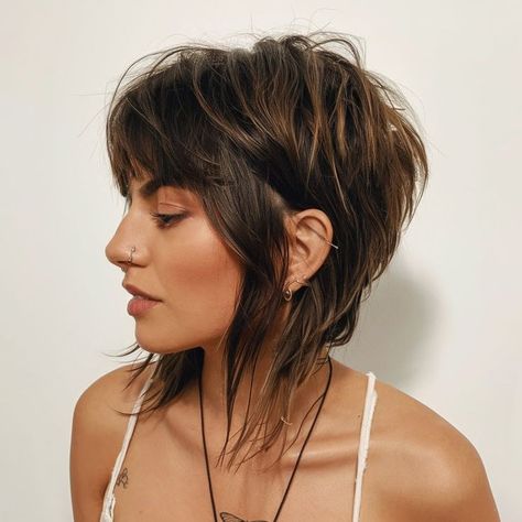 This fall haircut offers a bold, playful vibe with its edgy shaggy bob and wispy bangs. The choppy layers provide volume and movement, creating a dynamic style perfect for those looking to make a statement. The dark roots with lighter tips add contrast, enhancing the haircut’s rebellious charm. Piecy Bob Hairstyles, Choppy Bob Hairstyles For Fine Hair Short Styles, Short Hairstyle Women Round Face Bob Haircuts Thick Hair Straight, Shoulder Length Choppy Layers, Short Edgy Bob, Short Layered Haircuts Shoulder Length, Shaggy Haircuts With Bangs, Choppy Bob Hairstyles With Bangs, Fall Short Hair