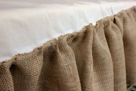 I pinned the burlap ribbon to each end and to the middle of the existing bed skirt. I pinched and pinned it all down. Then I sewed it right on top of the bedskirt. I used an entire roll for each side and half a roll for the end. Burlap Bedskirt, Burlap Bed Skirts, Cowgirl Princess, Pink Bed Sheets, Cowgirl Bedroom, Lace Curtain Panels, Burlap Ideas, Mother Daughter Projects, Upholstery Tacks