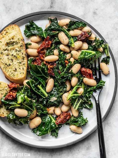 This quick Sun Dried Tomato, Kale, and White Bean Skillet is a fast, flavorful, and fiber-licious meal that is ready for perfect for weekly meal prepping. Budgetbytes.com White Bean Skillet, Greens And Beans, Kale And White Bean, Vegetarian Foods, Meatless Recipes, Meatless Mondays, Idee Pasto, Läcker Mat, Diet Vegetarian