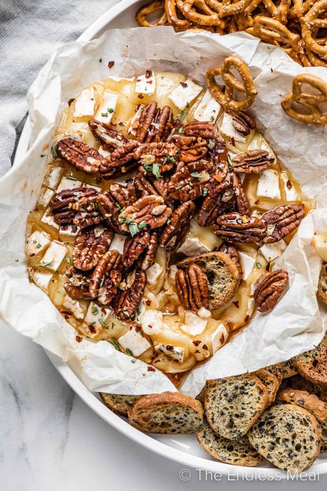 This hot honey baked brie is gooey and sweet with a little heat. It's a wheel of brie cheese baked with homemade hot honey, and topped with pecans and fresh rosemary. It's an easy party appetizer that everyone loves, and it's ready in just 20 minutes! #theendlessmeal #bakedbrie #cheeseboard #brie #partyrecipes #holidayrecipes Honey Baked Brie, Baked Brie Honey, Homemade Hot Honey, Honey Appetizers, Honey Brie, Brie Cheese Recipes, Hot Honey Recipe, Pecan Baked Brie, Baked Brie Appetizer