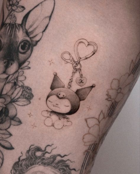 A tattoo of a keychain with a Sanrio character called Kuromi. She has her eyes closed and is surrounded by sparkles. The tattoo is in black and grey with soft shading and fine lines. Charms Tattoo, Keychain Tattoo, Kuromi My Melody Tattoo, Tattoo Flash Ideas, Windchime Tattoo, Kuromi Tattoo Aesthetic, Cute Clown Tattoo, Sanrio Tattoos, Kuromi Tattoo