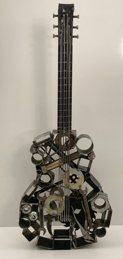 Custom metal art guitar sculpture. This is a one of a kind, original, welded, clear coated, metal sculpture. Fantastic piece of art for indoor or outdoor display. It can stand freely or be mounted on a wall by a professional. The guitar has been hand crafted out of various metal items such as bolts, washers nuts etc. Welded together and clear coated for protection. There are also a couple of American made tools welded into this piece along with other items.  Dimensions: Weight 34lbs. Height 40 inches  Width 15.5 inches Found Material Sculpture, Sculpture Art Metal, Welding Crafts Junk Art, Guitar Sculpture, Scrap Metal Sculpture, Junk Metal Art, Welded Metal Art, Metal Art Projects Ideas, Art Guitar