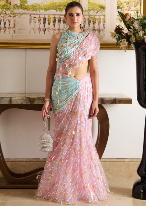 A pastel parade of summery hues, the zil saree reflects a softcore siren with its structured silhouette, featuring a draped blouse and a pre-stitched mermaid-style skirt. The designer blouse boasts a joyous play of sequins, paired with a pre-draped skirt crafted from tulle fabric and draped using innovative techniques with sequin embellishments. The droplet detailing, crafted from sequins and crystals, adorns the entire silhouette, making it the key feature of this exotic ensemble. Draped blouse featuring a play of sequins with a glamorous back. Pre-draped mermaid-style skirt crafted out of tulle fabric is adorned with pastel-hued sequins. Blouse has a left-hand open metal zip. Skirt has a closed metal zip on the left side. Luxury Embroidered Pre-draped Saree For Festivals, Designer Wear Fitted Pre-draped Saree, Designer Fitted Pre-draped Saree For Designer Wear, Designer Fitted Pre-draped Saree, Draped Sharara For Party, Fitted Lehenga With Draped Sleeves For Parties, Designer Party Saree With Unstitched Blouse, Designer Pre-draped Saree With Dupatta For Party, Designer Party Pre-draped Saree With Dupatta